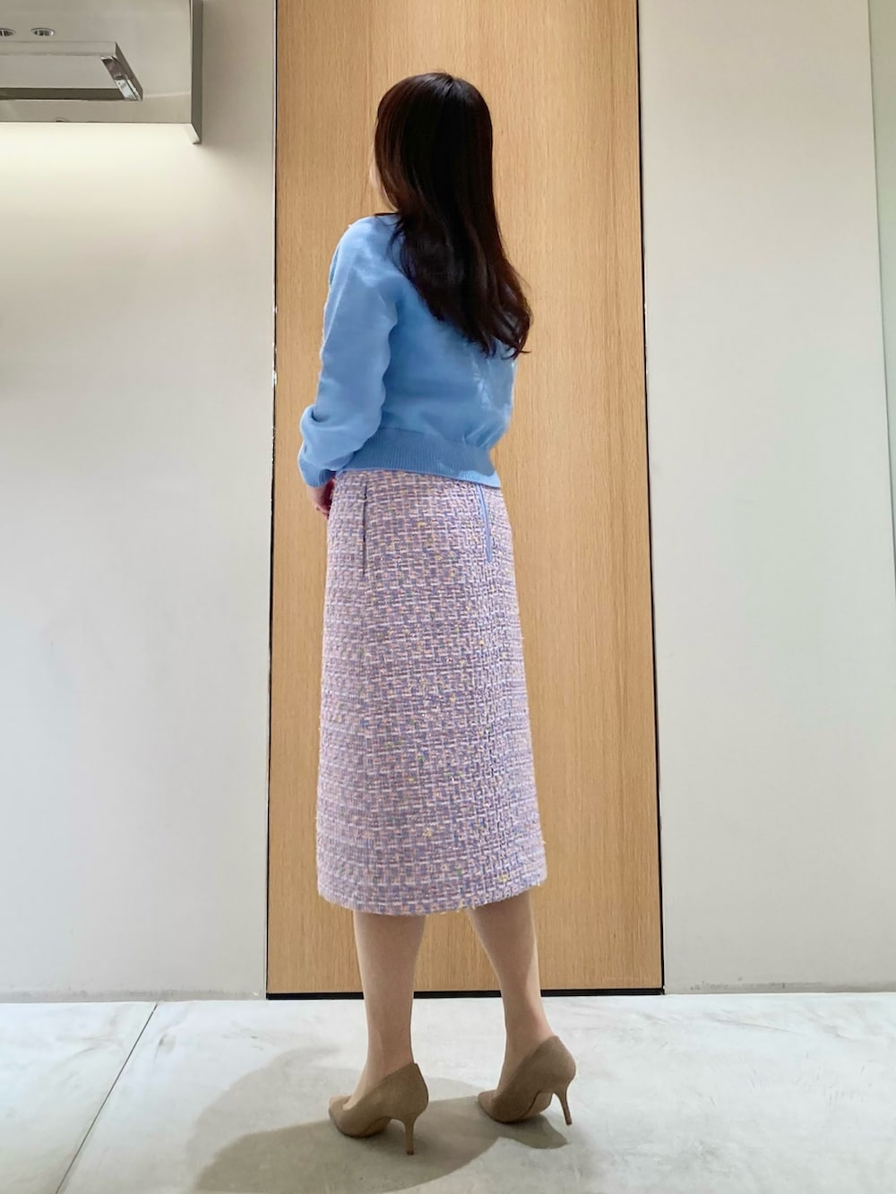 ブルー系のカーディガン/ボレロ、ブルー系のスカート、ゴールド系のイヤリングを着用したレディースの春コーディネートの2枚目の写真