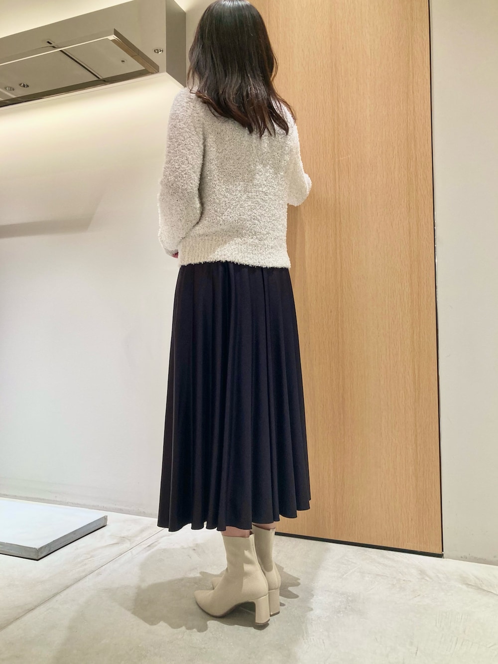 ホワイト系のカーディガン/ボレロ、ベージュ系のハンドバッグ、グレー系のスカートを着用したレディースの秋コーディネートの3枚目の写真