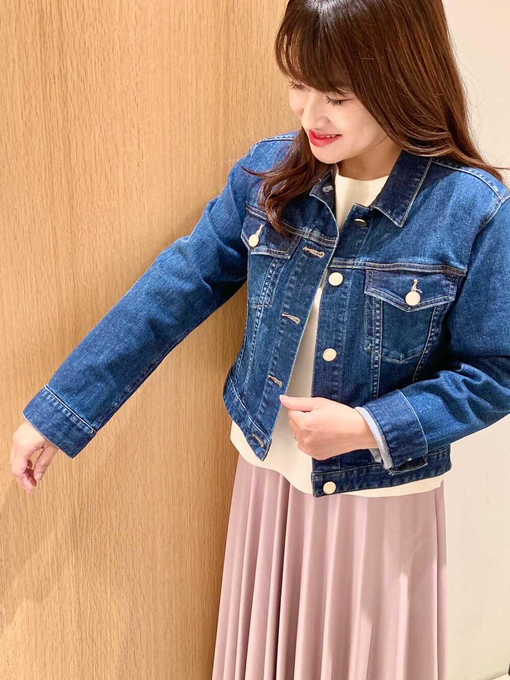 ブルー系のデニムジャケット、ホワイト系のニット/セーター、ピンク系のスカートを着用したレディースの秋コーディネートの7枚目の写真