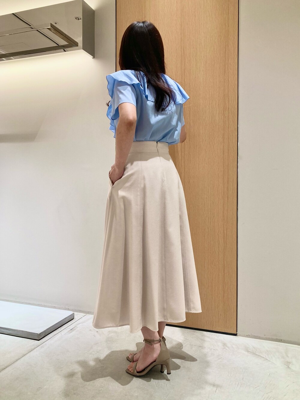 ブルー系のシャツ/ブラウス、ベージュ系のスカート、ホワイト系のイヤリングを着用したレディースの夏コーディネートの3枚目の写真