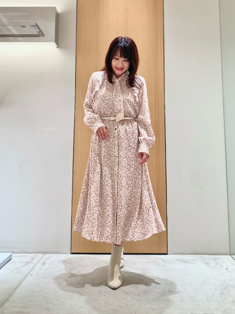 ベージュ系のその他アウター、ベージュ系のワンピース、ホワイト系のベルトを着用したレディースの秋コーディネートの3枚目の写真