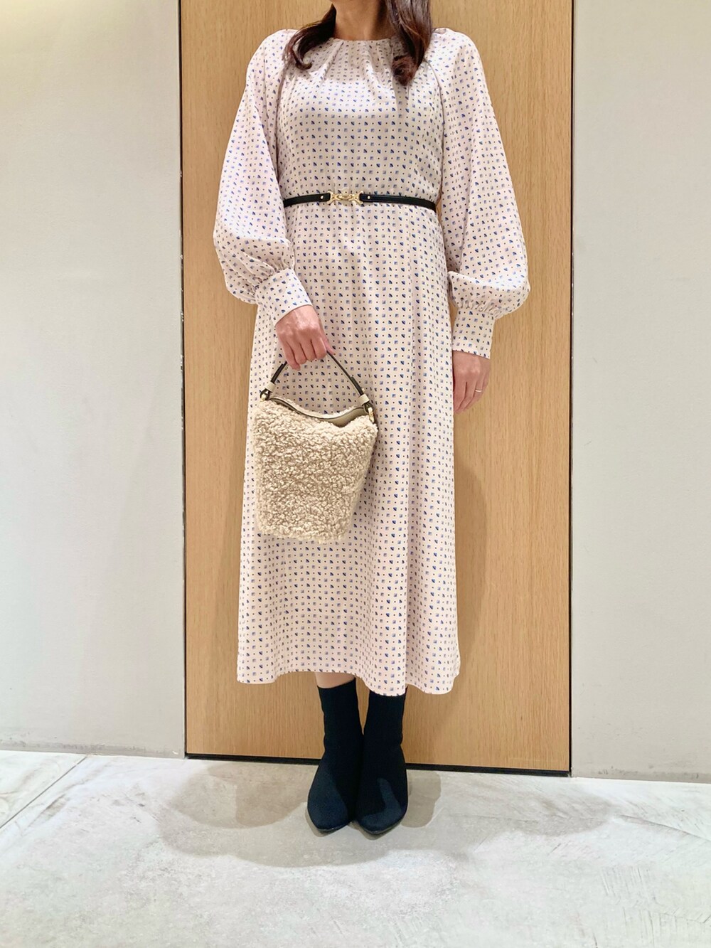 ベージュ系のワンピース、ホワイト系のハンドバッグを着用したレディースの秋コーディネートの4枚目の写真