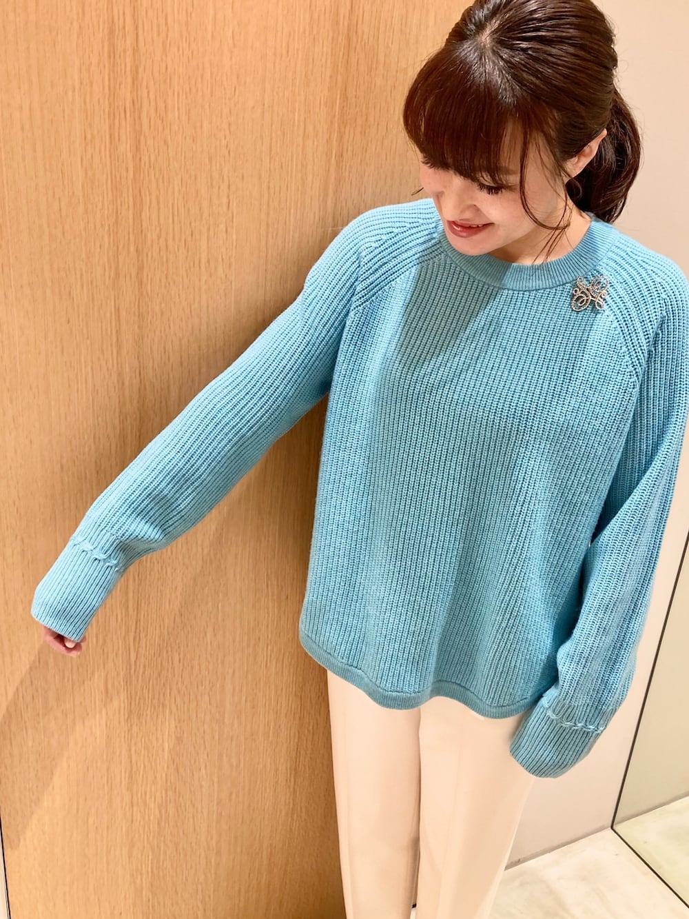 ブルー系のニット/セーター、グレー系のハンドバッグ、ホワイト系のその他パンツを着用したレディースの秋コーディネートの4枚目の写真