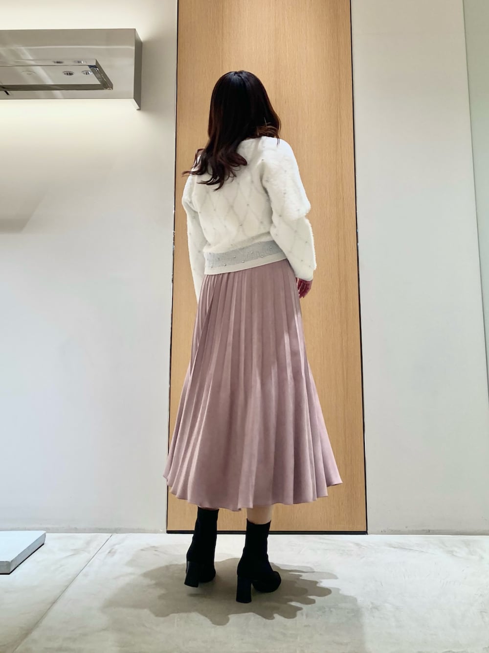 ホワイト系のニット/セーター、ピンク系のスカートを着用したレディースの冬コーディネートの3枚目の写真