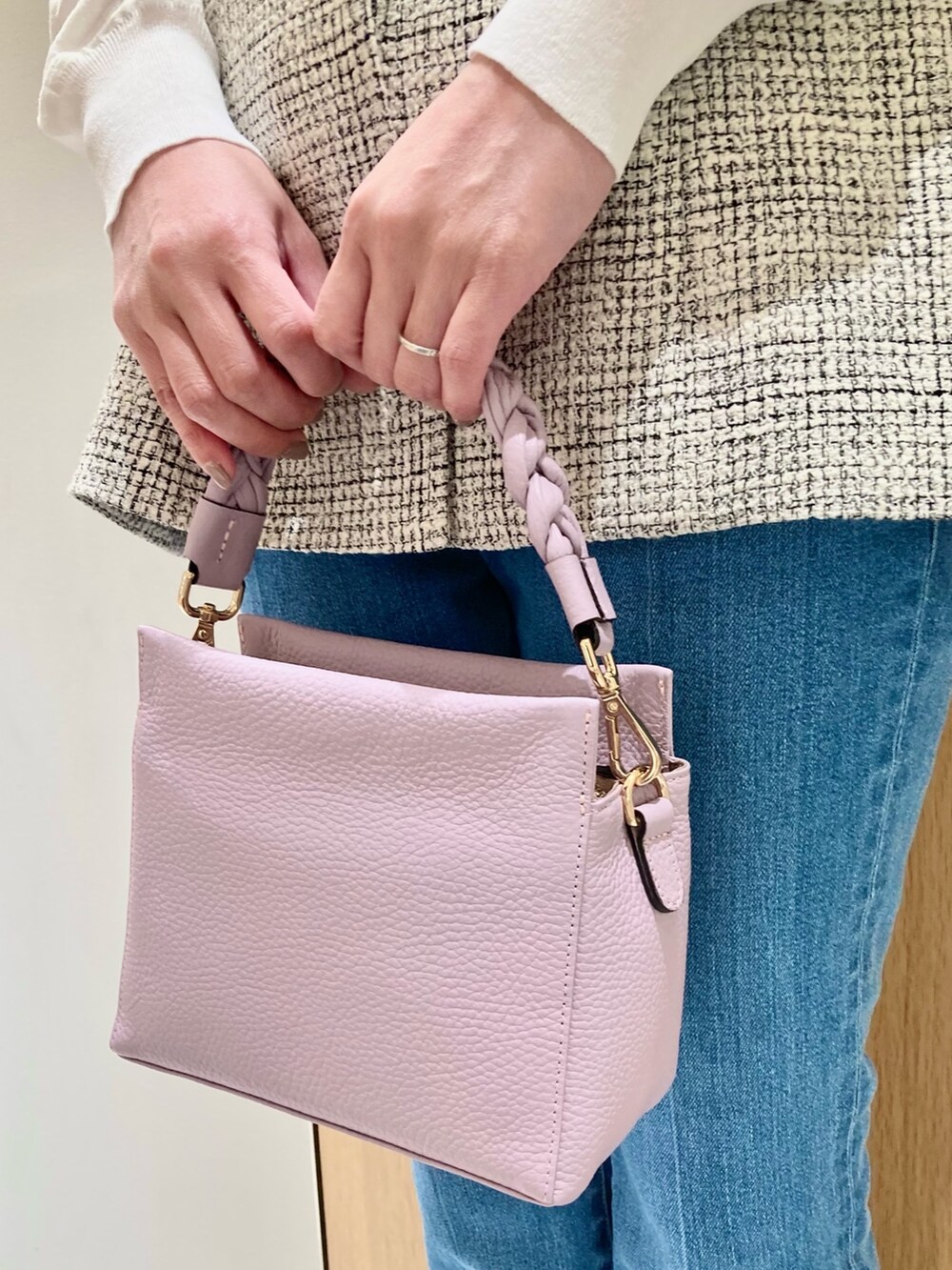 ホワイト系のニット/セーター、ホワイト系のベスト、ブルー系のデニムパンツを着用したレディースの春コーディネートの9枚目の写真