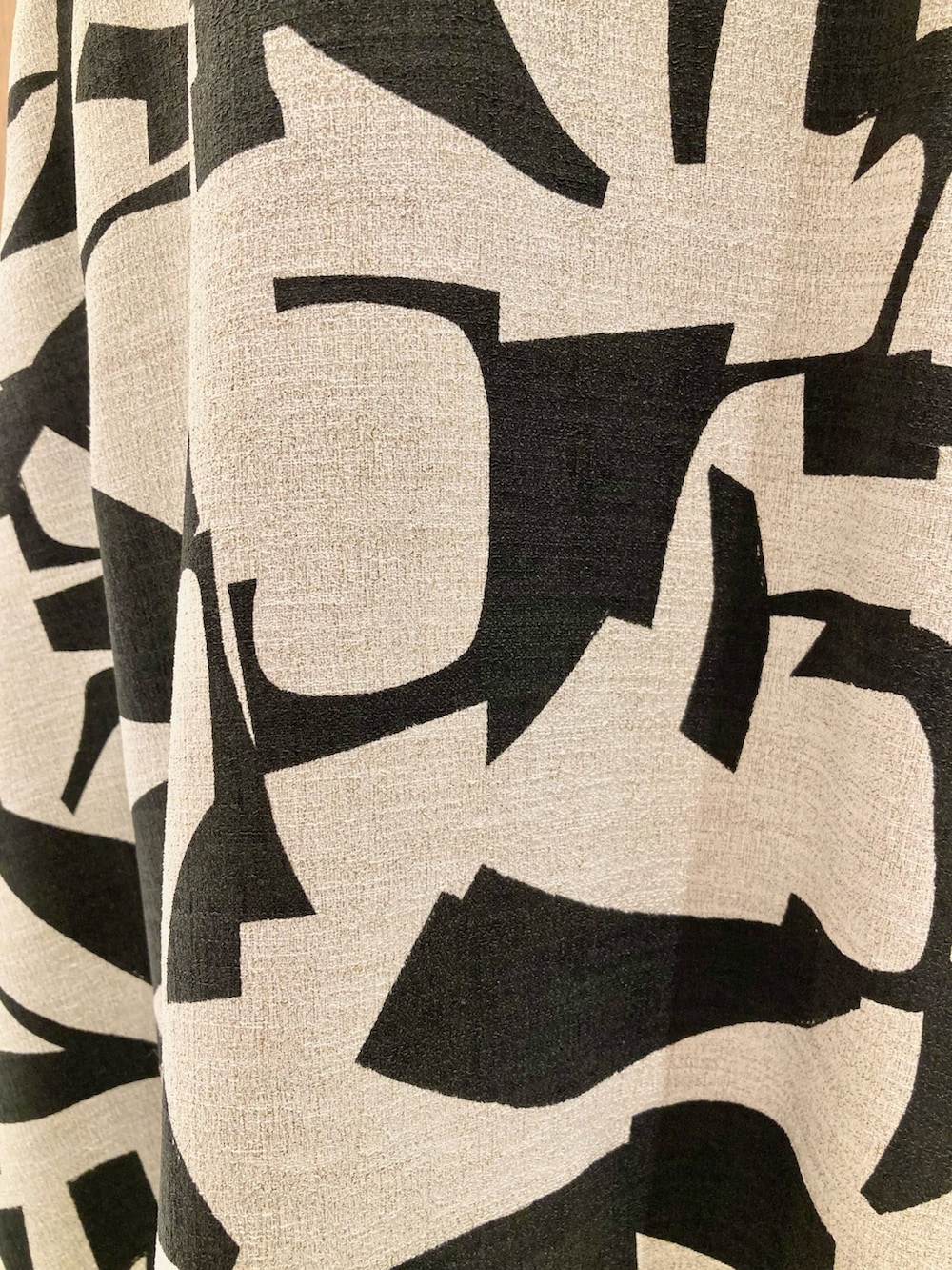 ブラック系のTシャツ/カットソー、ベージュ系のスカート、ブラック系のハンドバッグを着用したレディースの春コーディネートの10枚目の写真