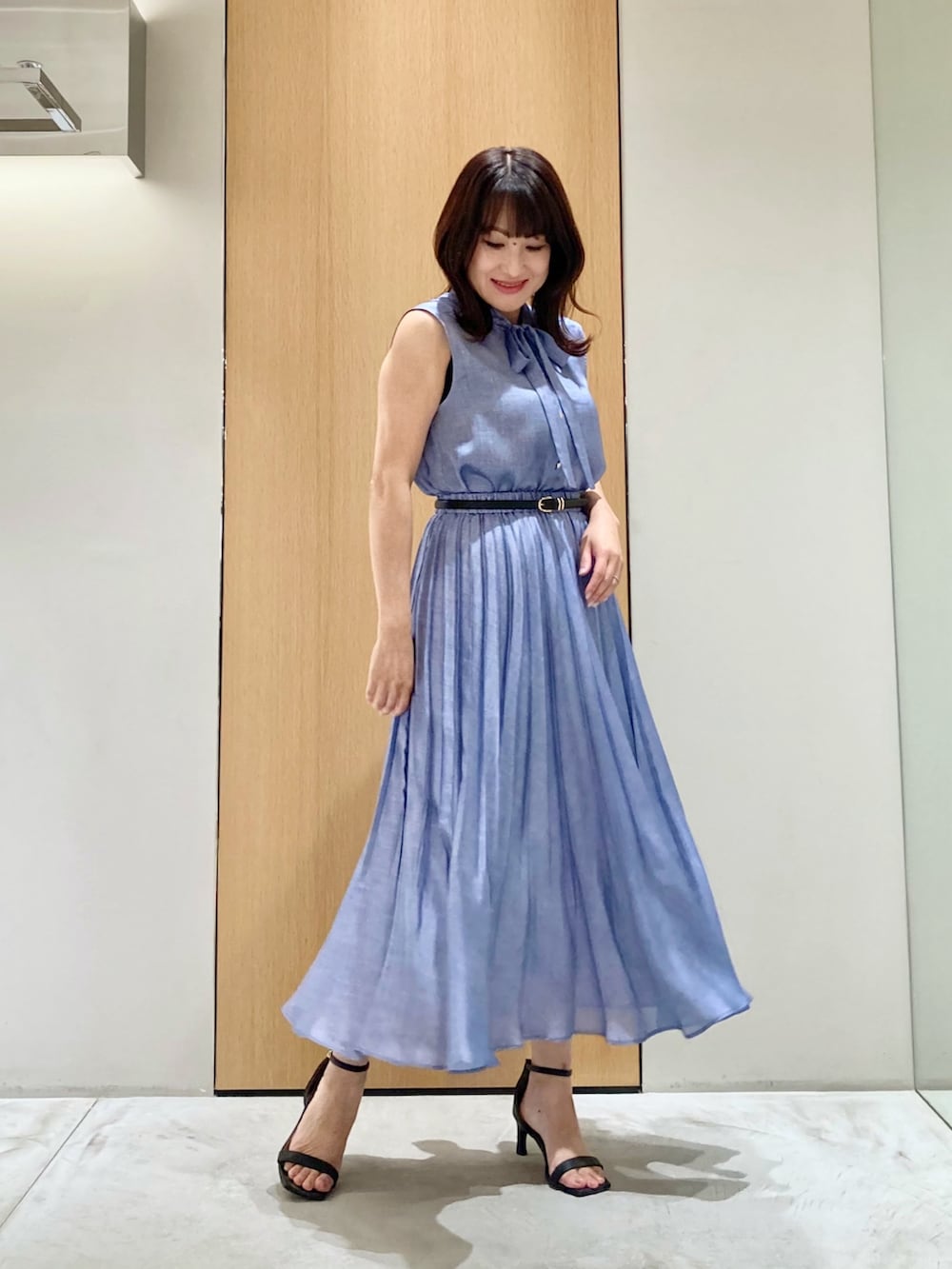 ブルー系のシャツ/ブラウス、ブルー系のスカート、ブラック系のベルトを着用したレディースの夏コーディネートの2枚目の写真