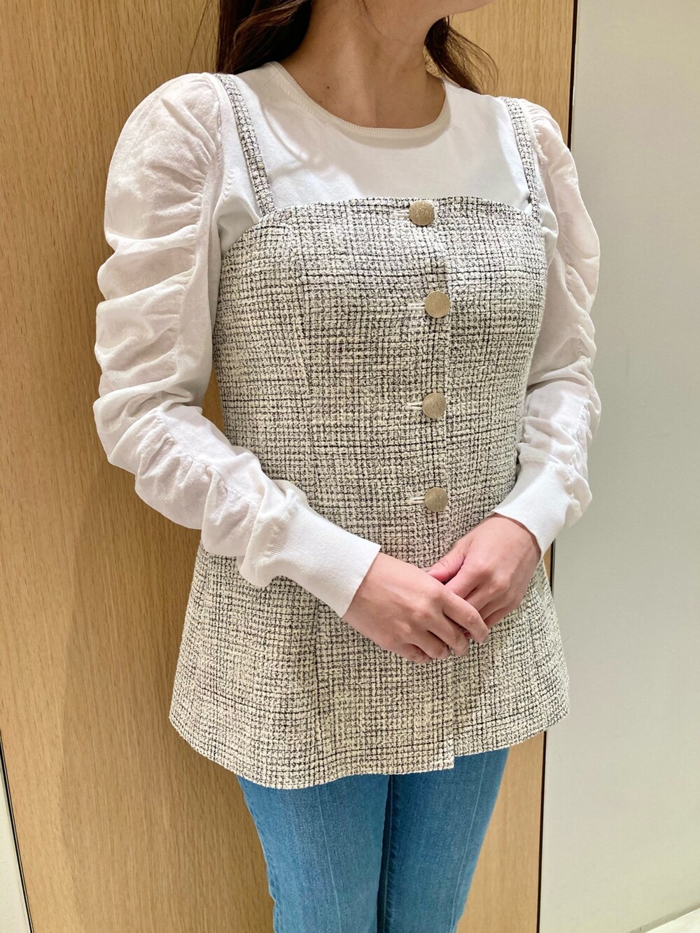 ホワイト系のニット/セーター、ホワイト系のベスト、ブルー系のデニムパンツを着用したレディースの春コーディネートの5枚目の写真