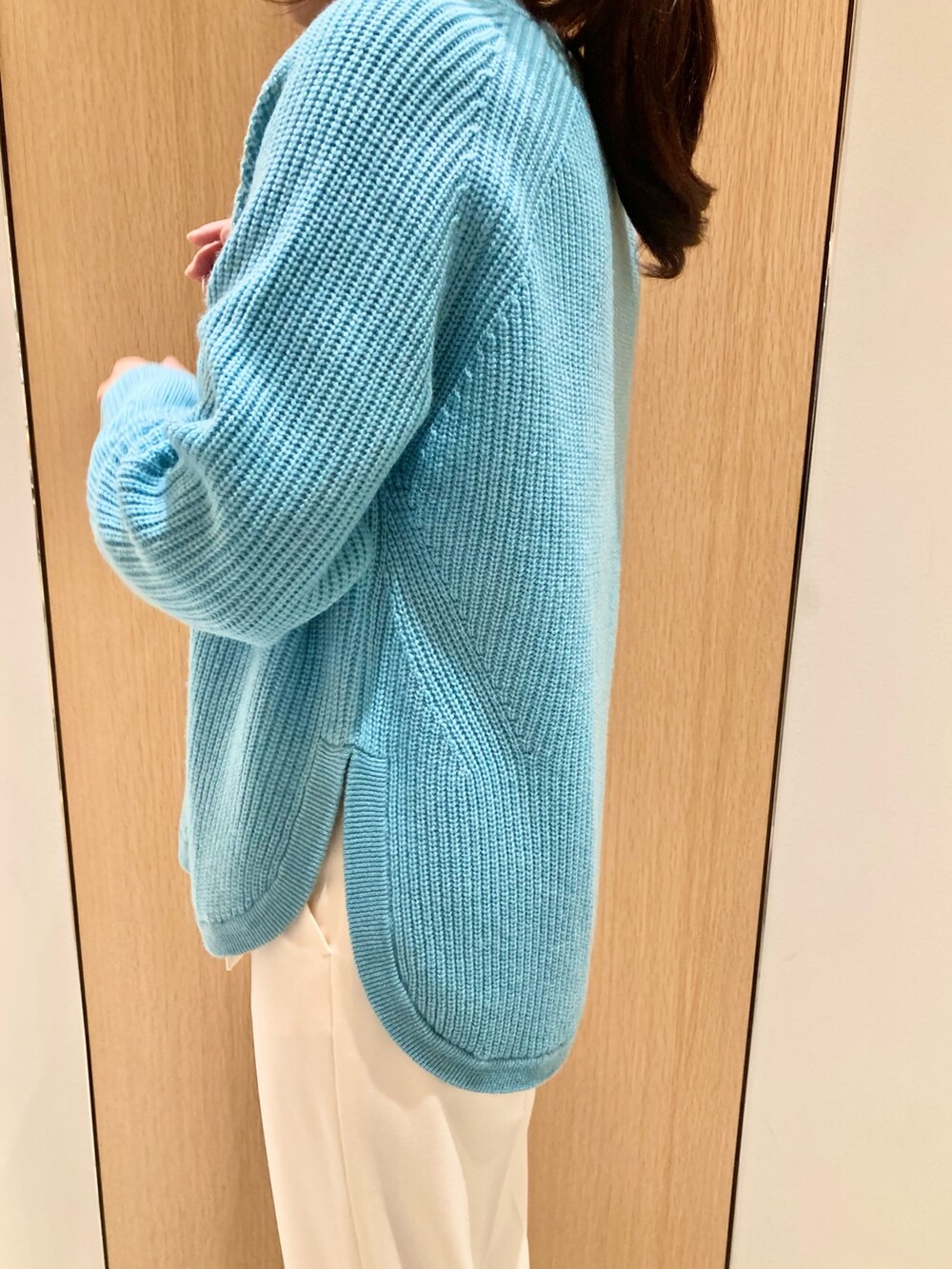 ブルー系のニット/セーター、グレー系のハンドバッグ、ホワイト系のその他パンツを着用したレディースの秋コーディネートの3枚目の写真