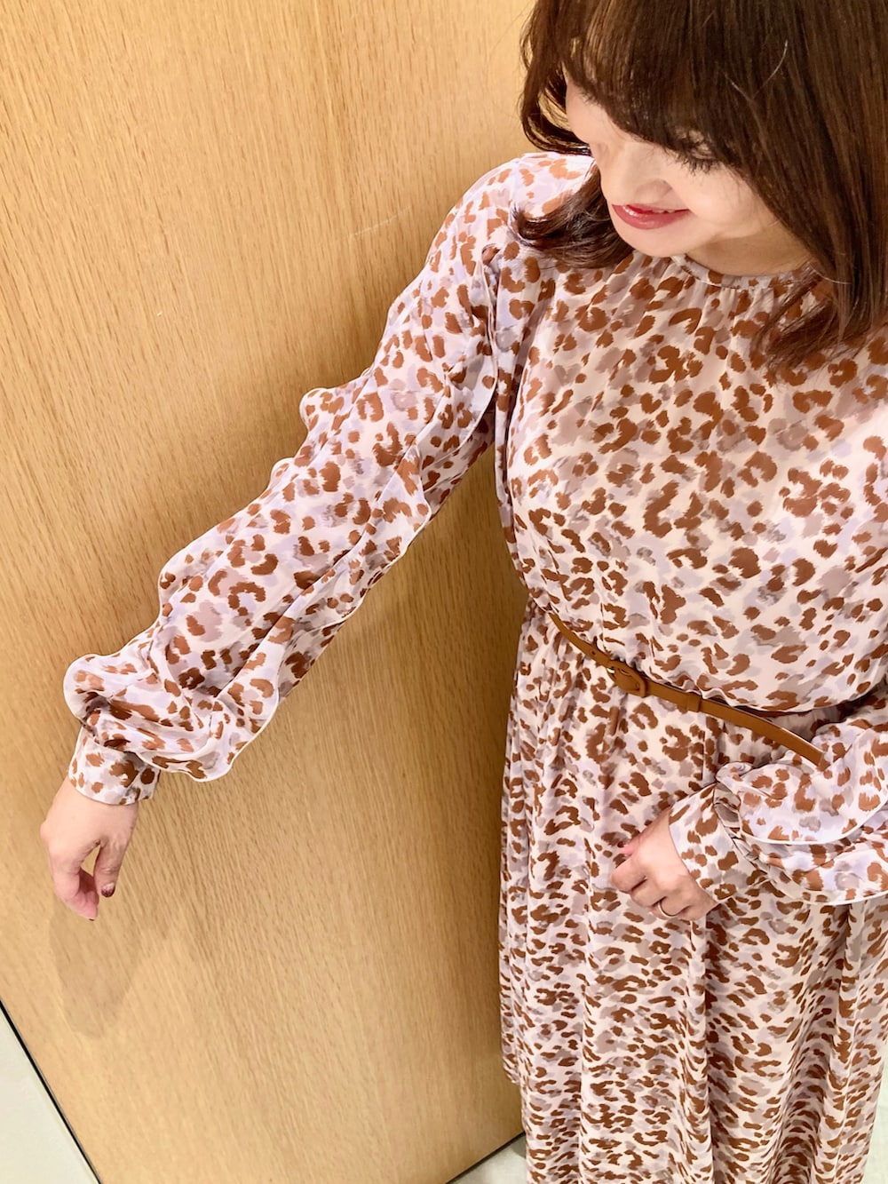 グレー系のワンピース、ピンク系のハンドバッグ、ゴールド系のリングを着用したレディースの秋コーディネートの5枚目の写真