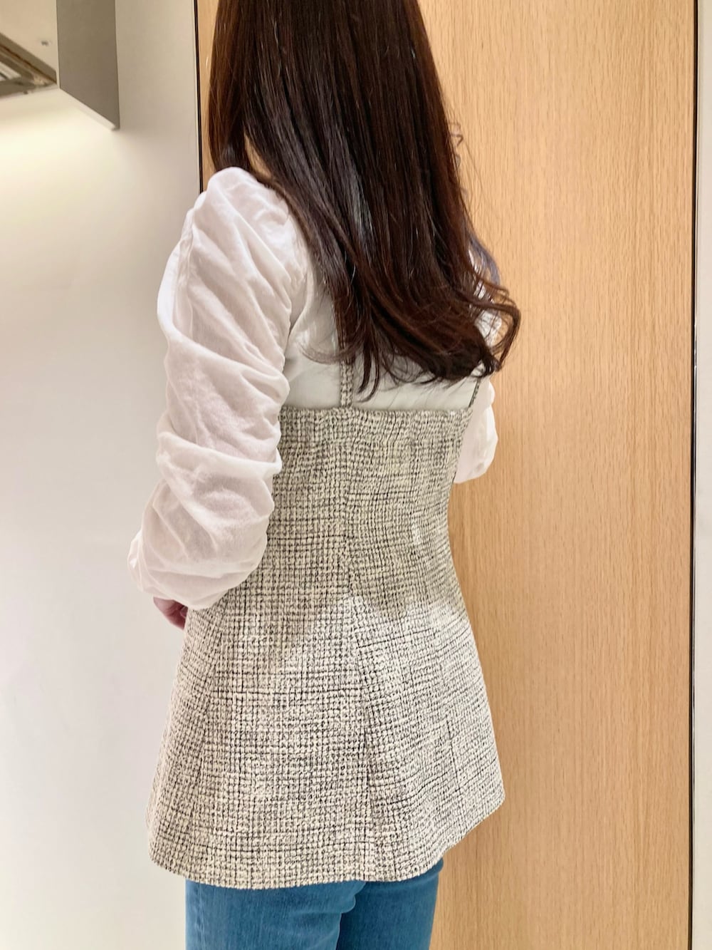 ホワイト系のニット/セーター、ホワイト系のベスト、ブルー系のデニムパンツを着用したレディースの春コーディネートの6枚目の写真