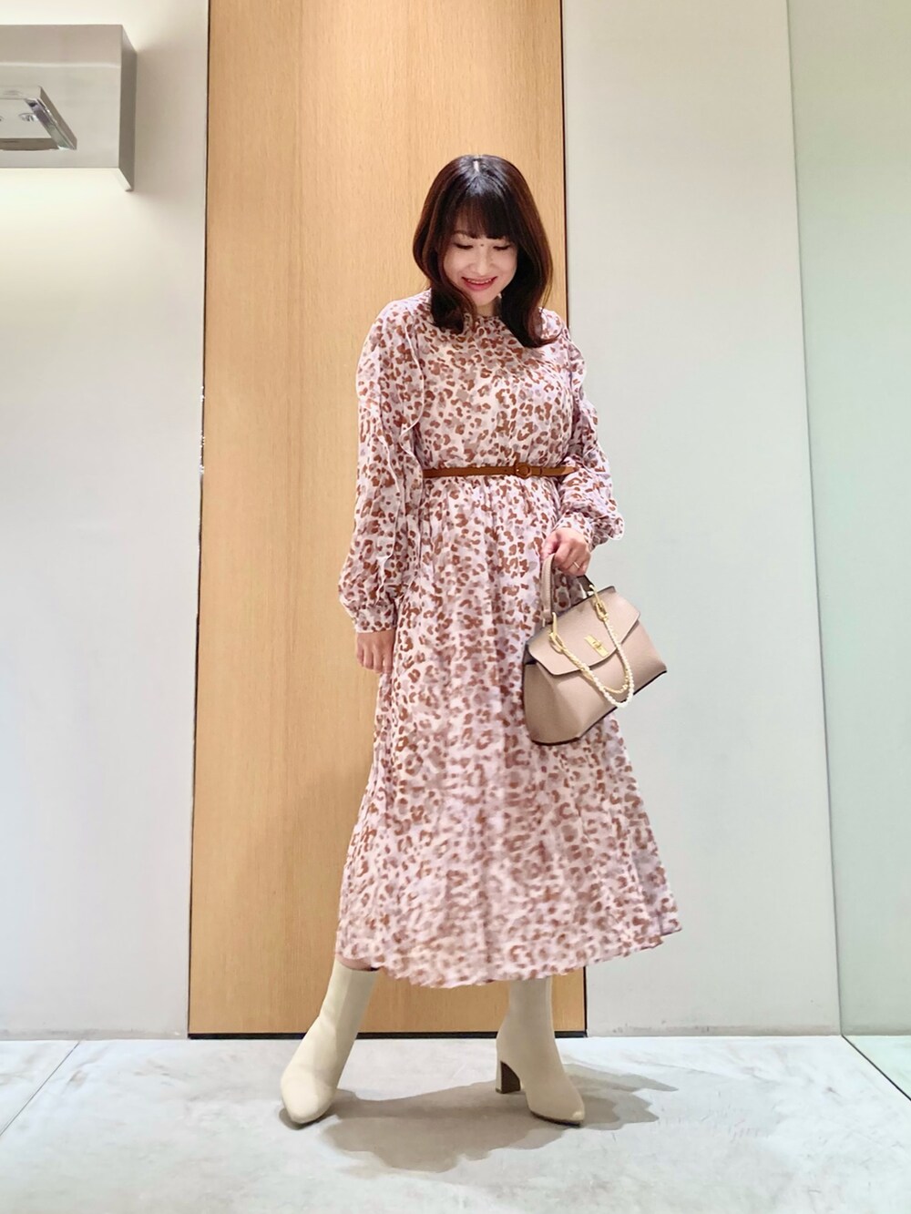 グレー系のワンピース、ピンク系のハンドバッグ、ゴールド系のリングを着用したレディースの秋コーディネートの2枚目の写真