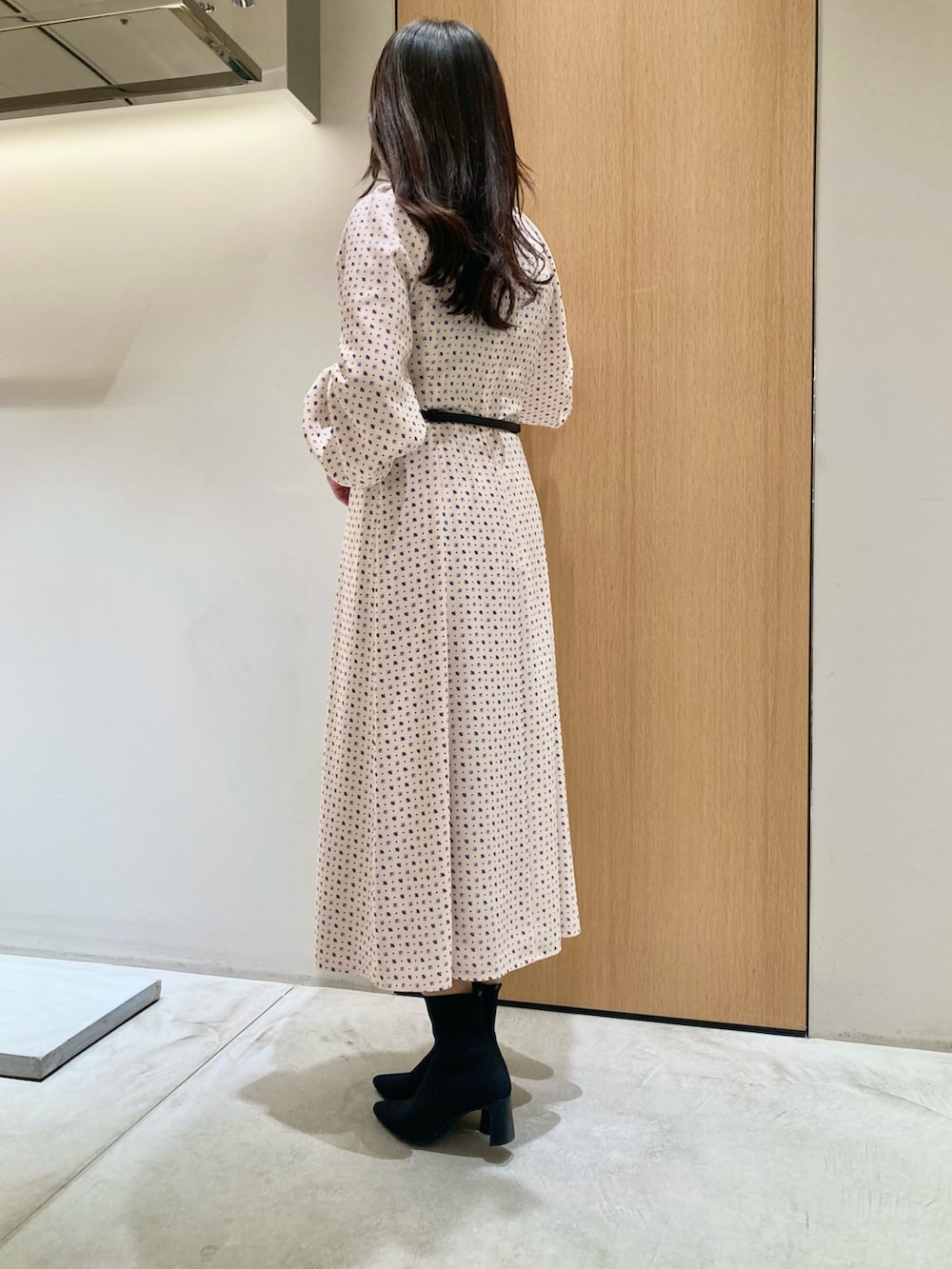 ベージュ系のワンピース、ホワイト系のハンドバッグを着用したレディースの秋コーディネートの3枚目の写真