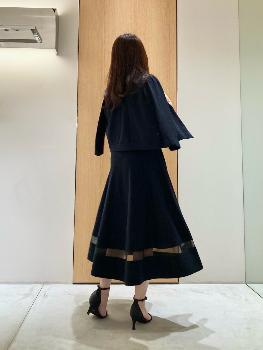 ブラック系のカーディガン/ボレロ、ブラック系のワンピース、ホワイト系のイヤリングを着用したレディースの春コーディネートの3枚目の写真