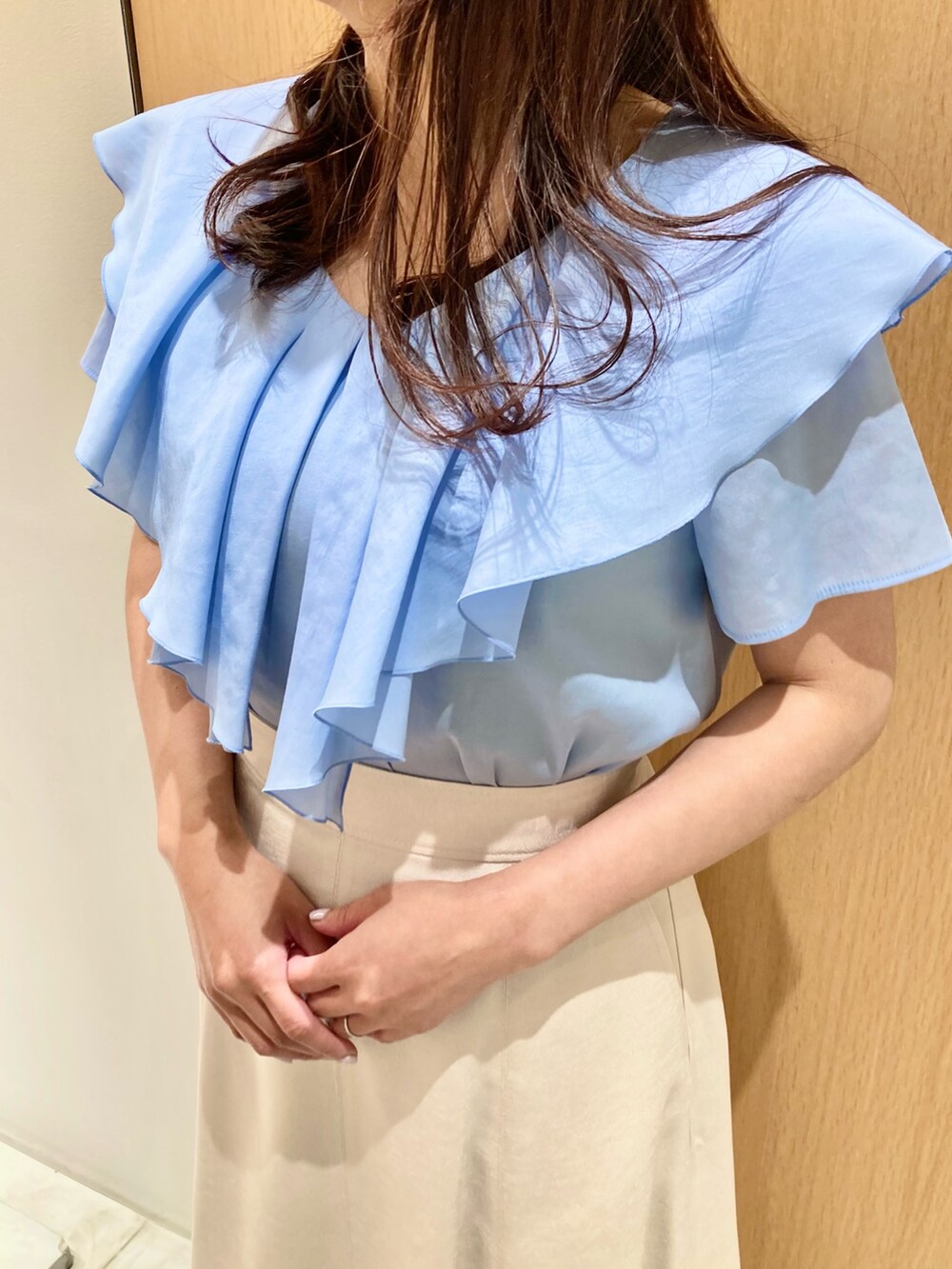 ブルー系のシャツ/ブラウス、ベージュ系のスカート、ホワイト系のイヤリングを着用したレディースの夏コーディネートの5枚目の写真