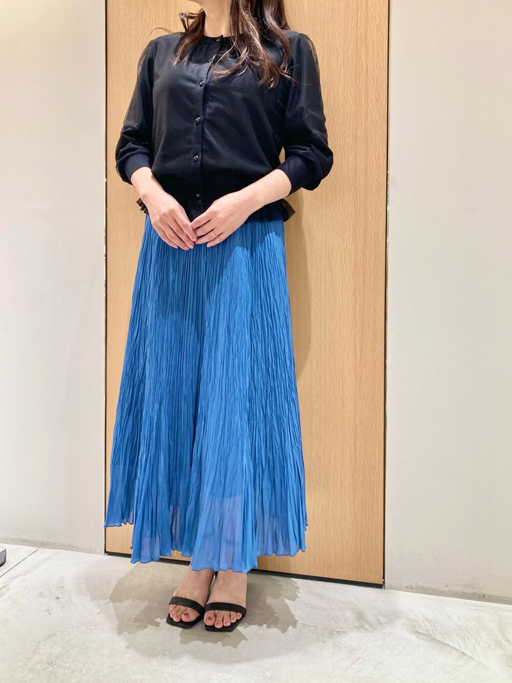 ブラック系のカーディガン/ボレロ、ブルー系のスカート、ホワイト系のイヤリングを着用したレディースの夏コーディネートの4枚目の写真