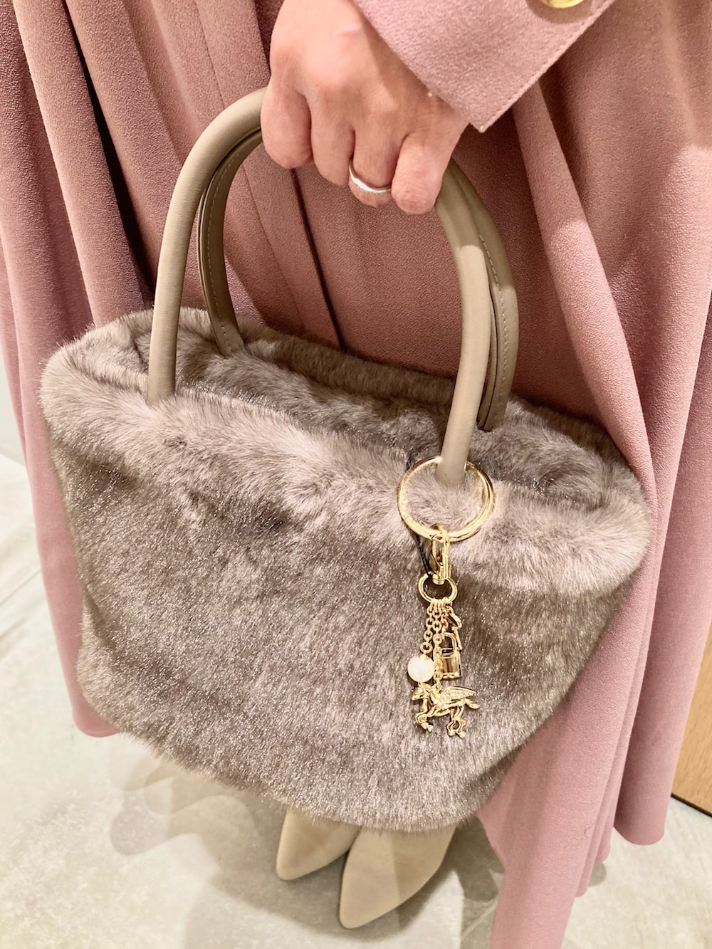 ピンク系のワンピース、ベージュ系のハンドバッグ、ゴールド系のリングを着用したレディースの秋コーディネートの8枚目の写真