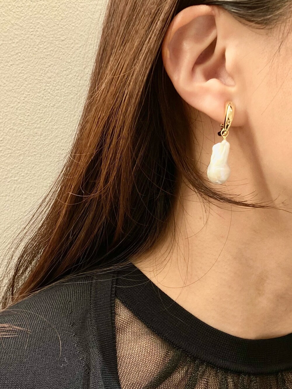 ブラック系のカーディガン/ボレロ、ブラック系のワンピース、ホワイト系のイヤリングを着用したレディースの春コーディネートの9枚目の写真