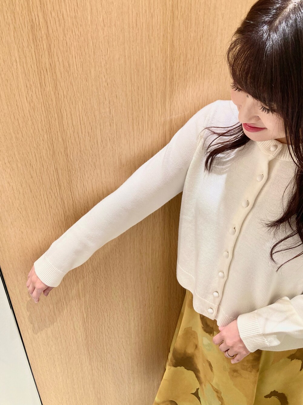 ホワイト系のカーディガン/ボレロ、イエロー系のスカートを着用したレディースの秋コーディネートの7枚目の写真