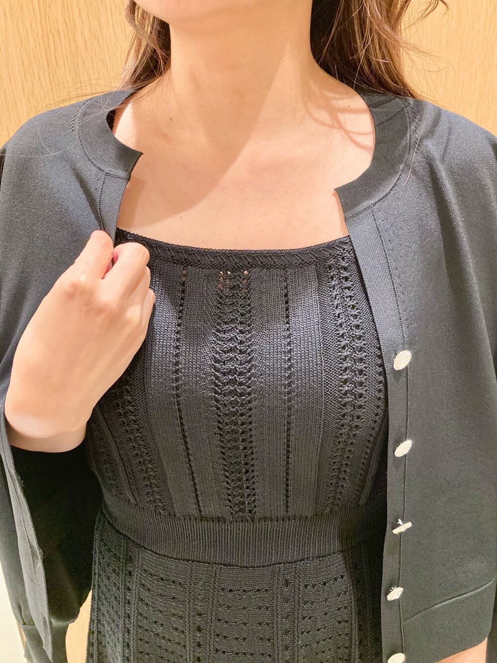 ブラック系のカーディガン/ボレロ、ブラック系のワンピース、レッド系のハンドバッグを着用したレディースの秋コーディネートの5枚目の写真