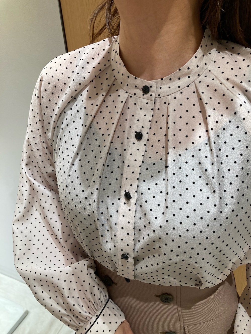 ベージュ系のシャツ/ブラウス、ベージュ系のスカート、ベージュ系のハンドバッグを着用したレディースの秋コーディネートの5枚目の写真