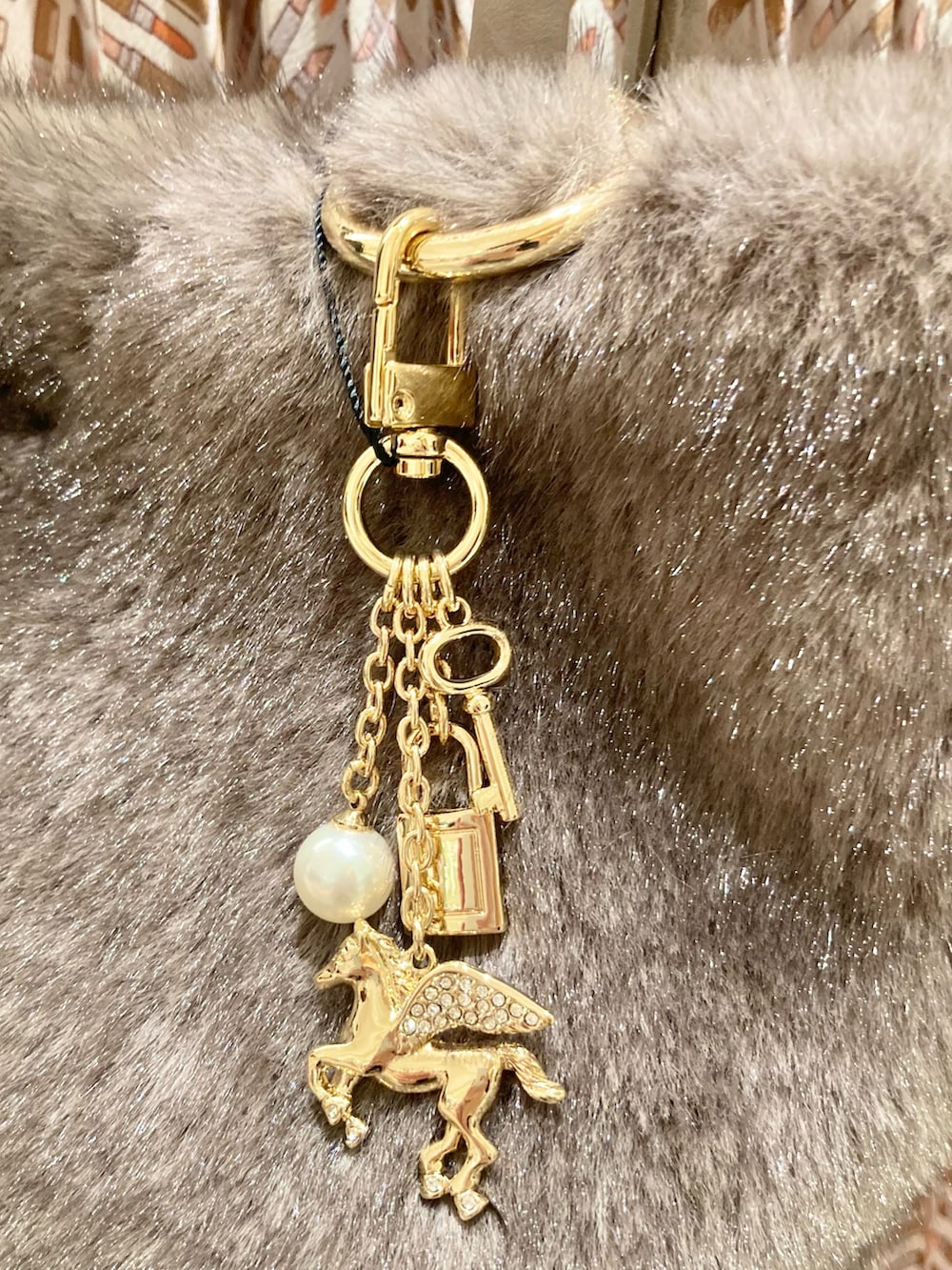 ピンク系のカーディガン/ボレロ、ベージュ系のスカート、ベージュ系のハンドバッグを着用したレディースの秋コーディネートの9枚目の写真