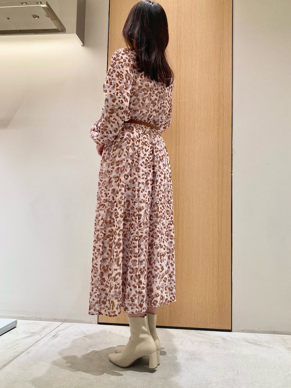 グレー系のワンピース、ピンク系のハンドバッグ、ゴールド系のリングを着用したレディースの秋コーディネートの3枚目の写真