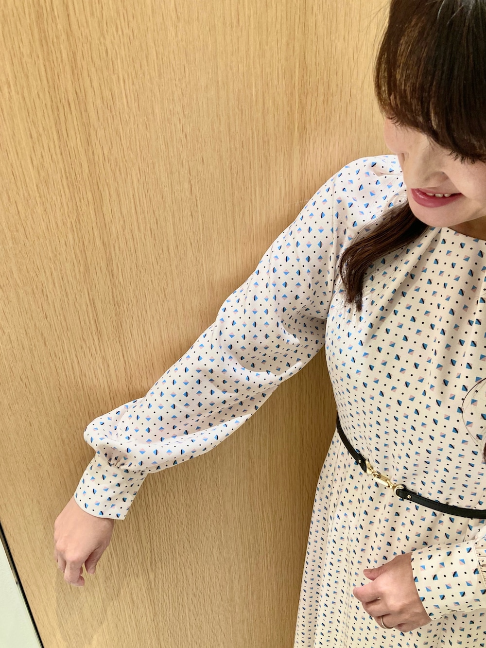 ベージュ系のワンピース、ホワイト系のハンドバッグを着用したレディースの秋コーディネートの6枚目の写真