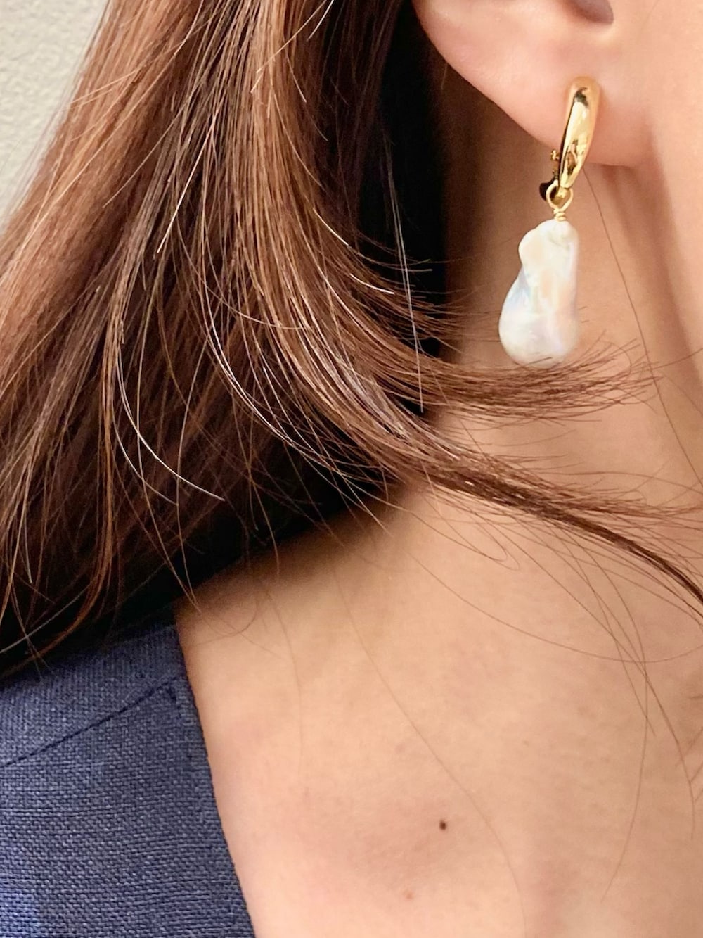 ブルー系のワンピース、ホワイト系のハンドバッグ、ホワイト系のイヤリングを着用したレディースの夏コーディネートの8枚目の写真