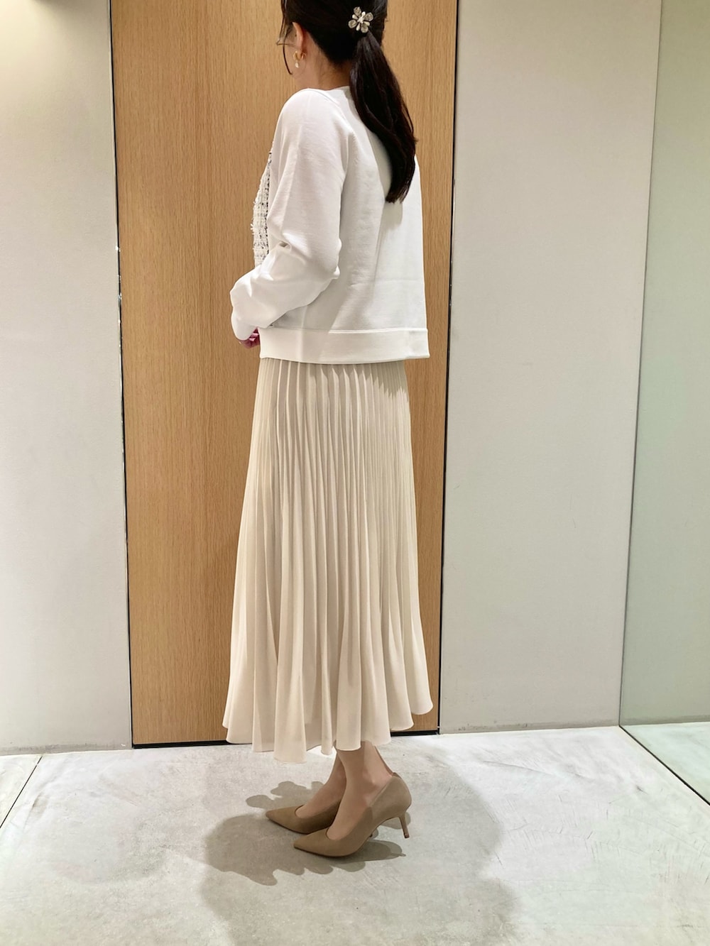 ホワイト系のカーディガン/ボレロ、ベージュ系のトートバッグ、ホワイト系のスカートを着用したレディースの冬コーディネートの3枚目の写真