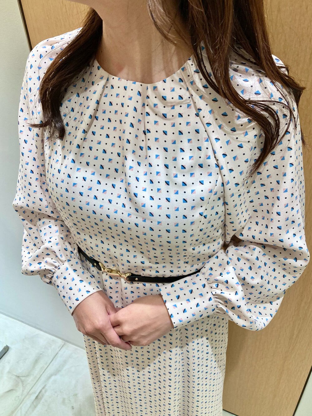 ベージュ系のワンピース、ホワイト系のハンドバッグを着用したレディースの秋コーディネートの5枚目の写真