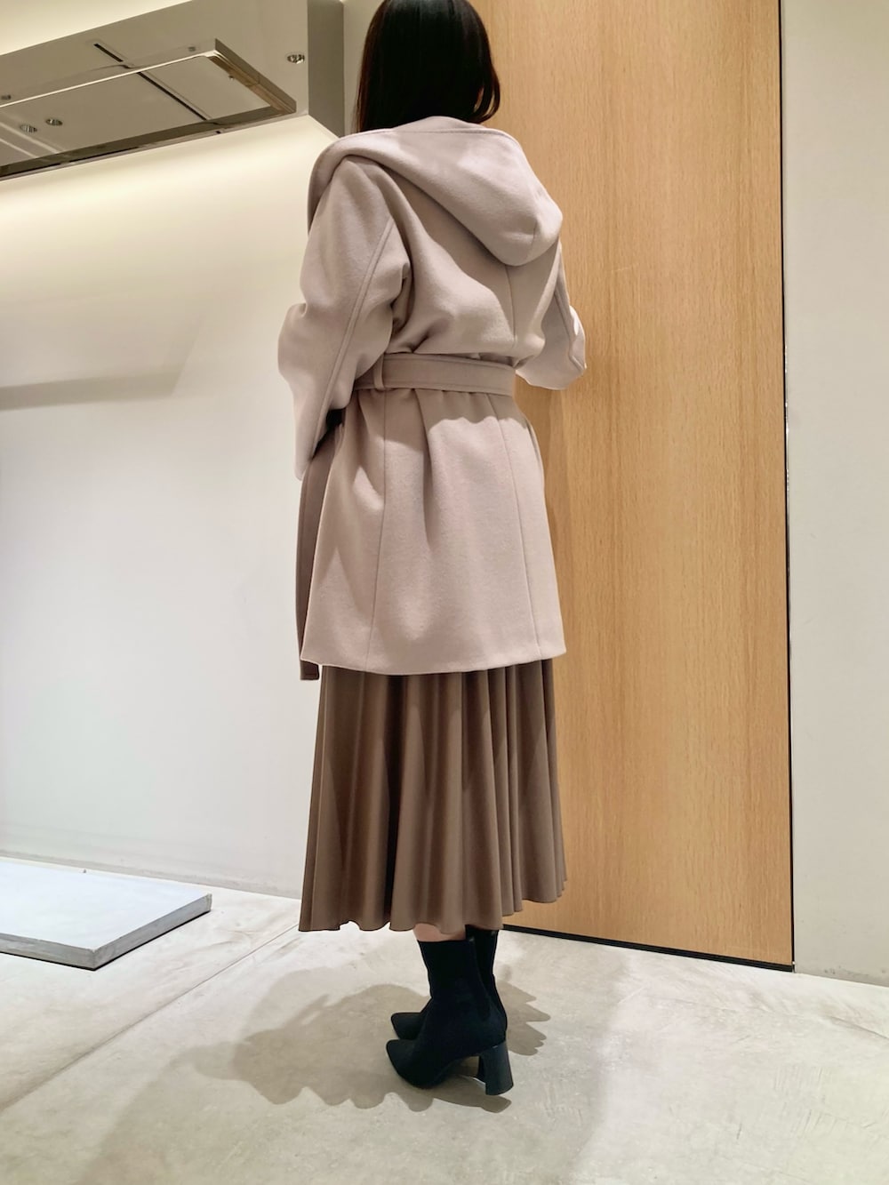 ベージュ系のその他アウター、ホワイト系のニット/セーター、ブラウン系のスカートを着用したレディースの秋コーディネートの2枚目の写真