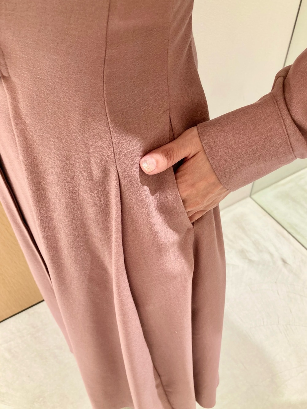 ピンク系のワンピース、ベージュ系のハンドバッグ、ゴールド系のリングを着用したレディースの秋コーディネートの7枚目の写真