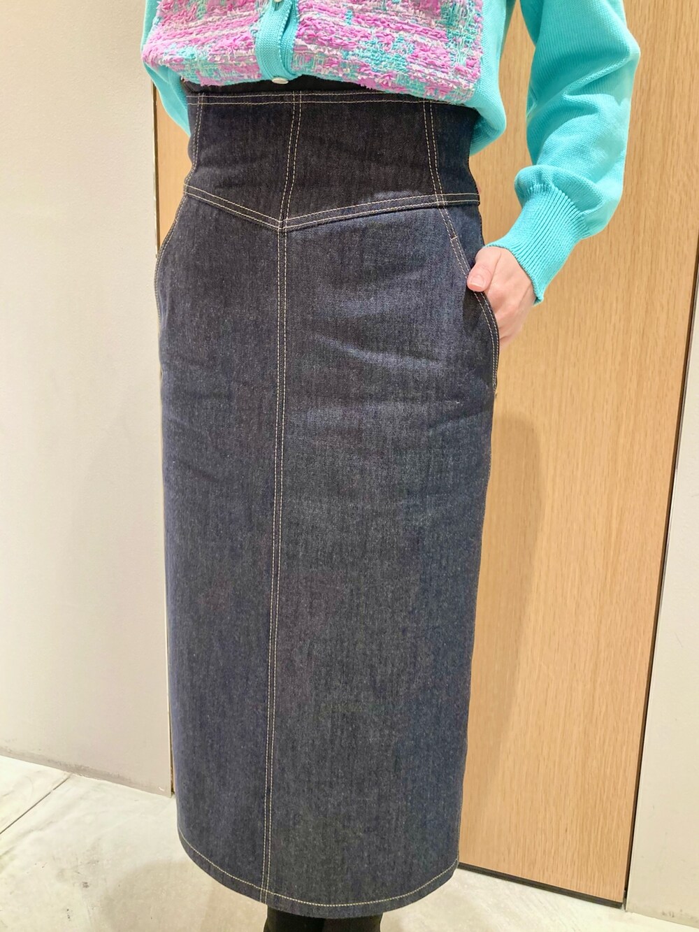 グリーン系のカーディガン/ボレロ、ホワイト系のハンドバッグ、ブルー系のデニムスカートを着用したレディースの冬コーディネートの8枚目の写真