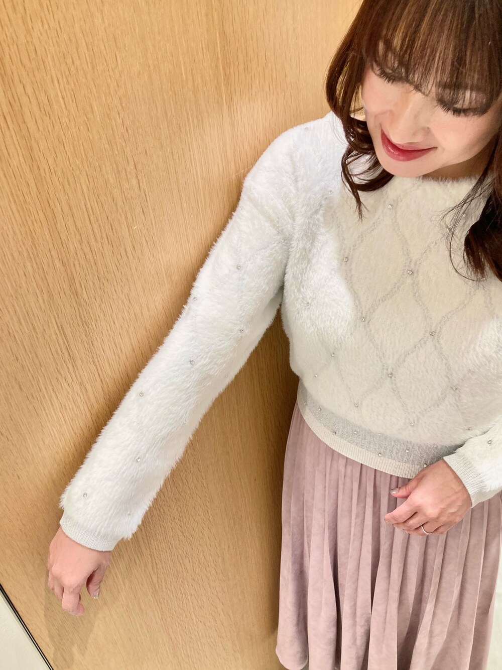 ホワイト系のニット/セーター、ピンク系のスカートを着用したレディースの冬コーディネートの6枚目の写真