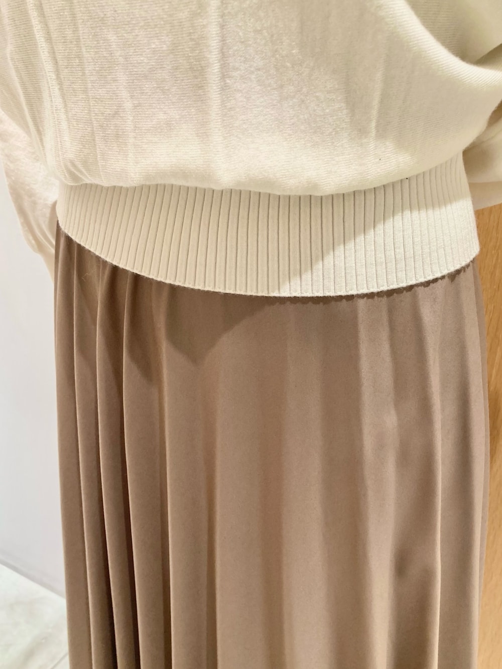 ベージュ系のその他アウター、ホワイト系のニット/セーター、ブラウン系のスカートを着用したレディースの秋コーディネートの6枚目の写真