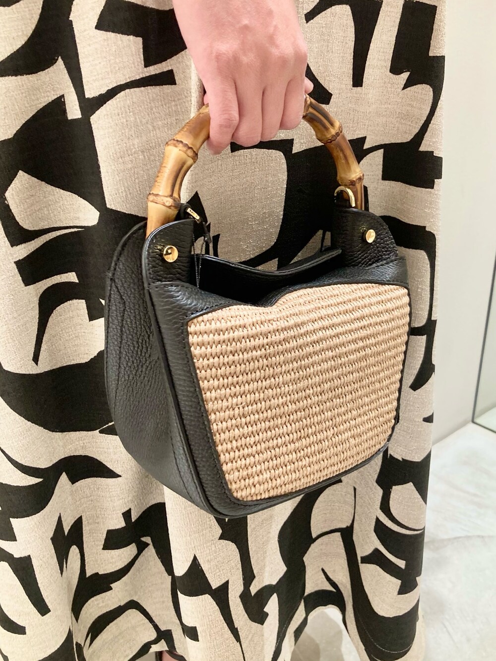 ブラック系のTシャツ/カットソー、ベージュ系のスカート、ブラック系のハンドバッグを着用したレディースの春コーディネートの9枚目の写真