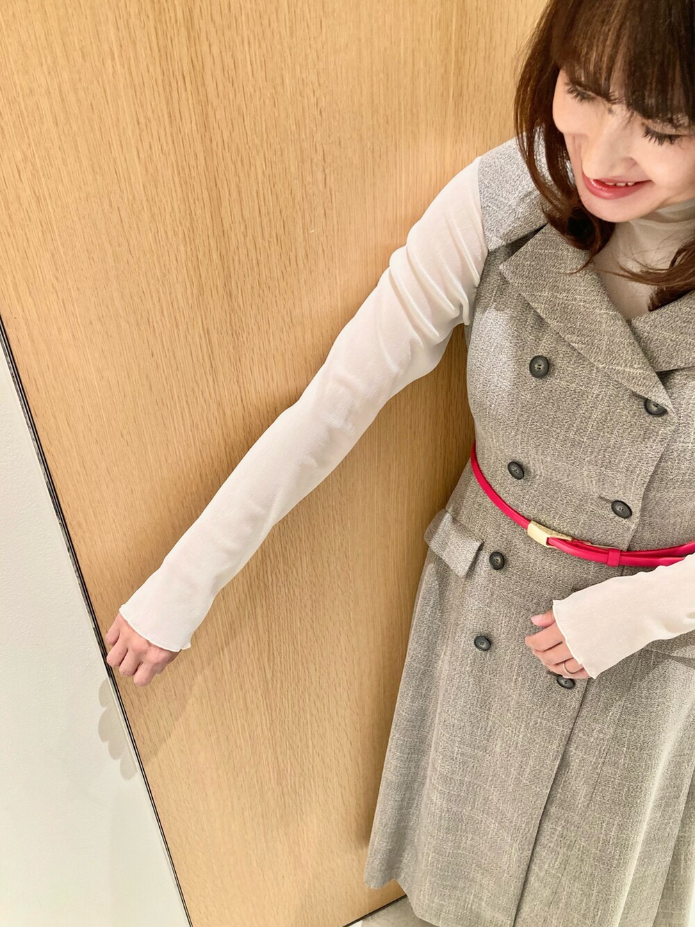 ベージュ系のワンピース、ホワイト系のTシャツ/カットソー、レッド系のベルトを着用したレディースの秋コーディネートの6枚目の写真