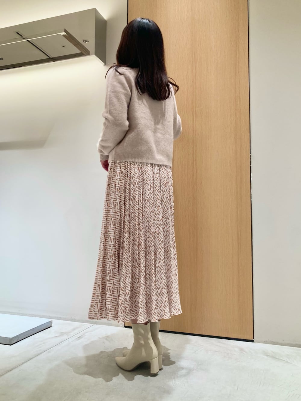 ピンク系のカーディガン/ボレロ、ベージュ系のスカート、ベージュ系のハンドバッグを着用したレディースの秋コーディネートの3枚目の写真