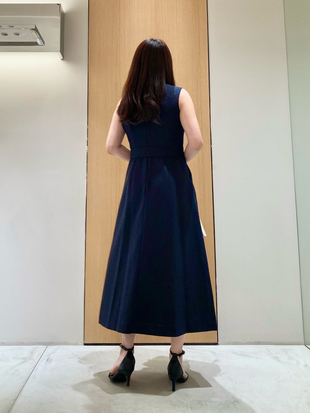 ブルー系のワンピース、ホワイト系のハンドバッグ、ホワイト系のイヤリングを着用したレディースの夏コーディネートの3枚目の写真