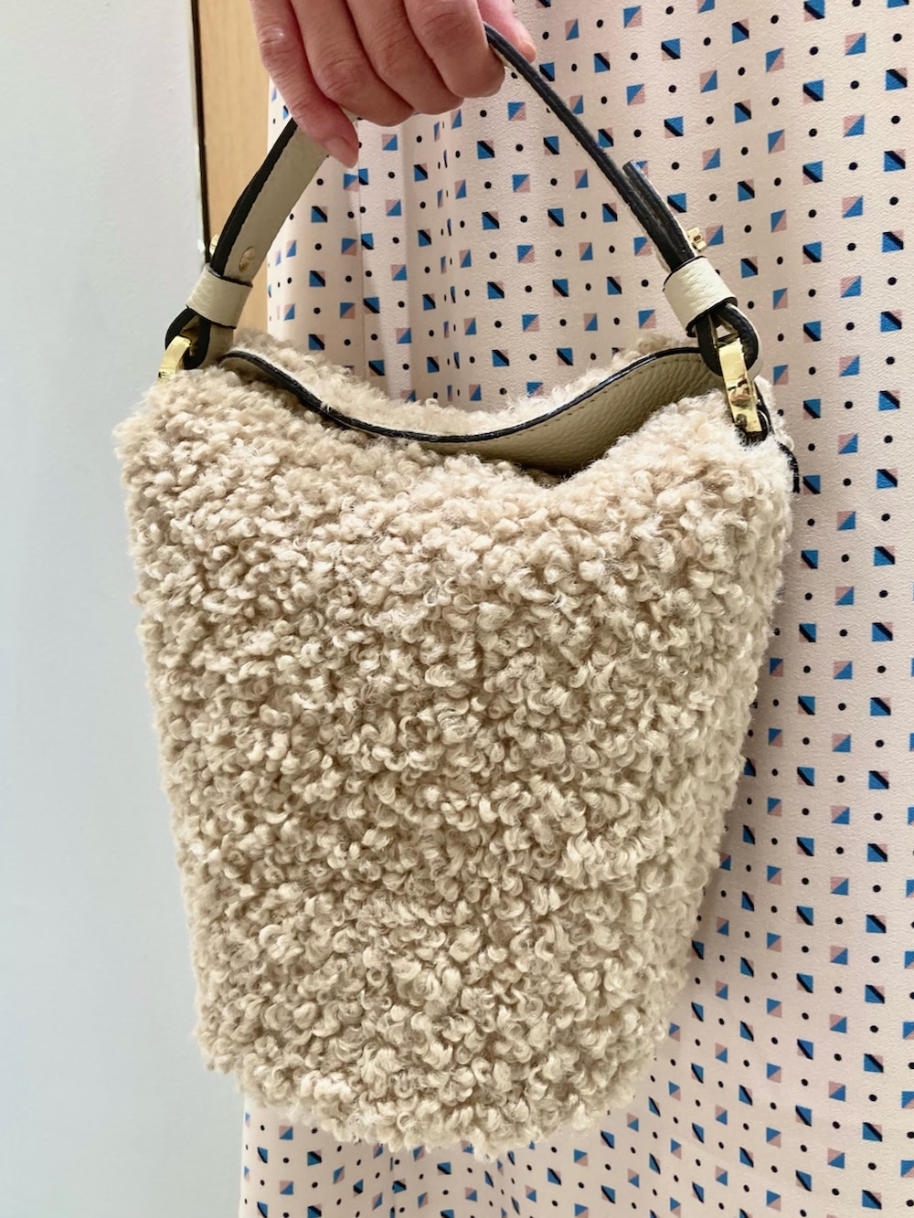 ベージュ系のワンピース、ホワイト系のハンドバッグを着用したレディースの秋コーディネートの9枚目の写真