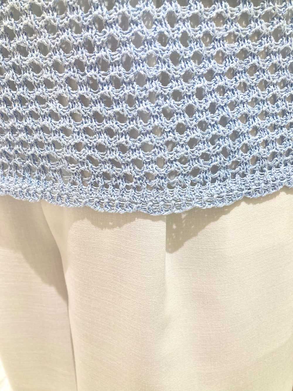 ブルー系のニット/セーター、ホワイト系のその他パンツ、ブルー系のハンドバッグを着用したレディースの夏コーディネートの4枚目の写真