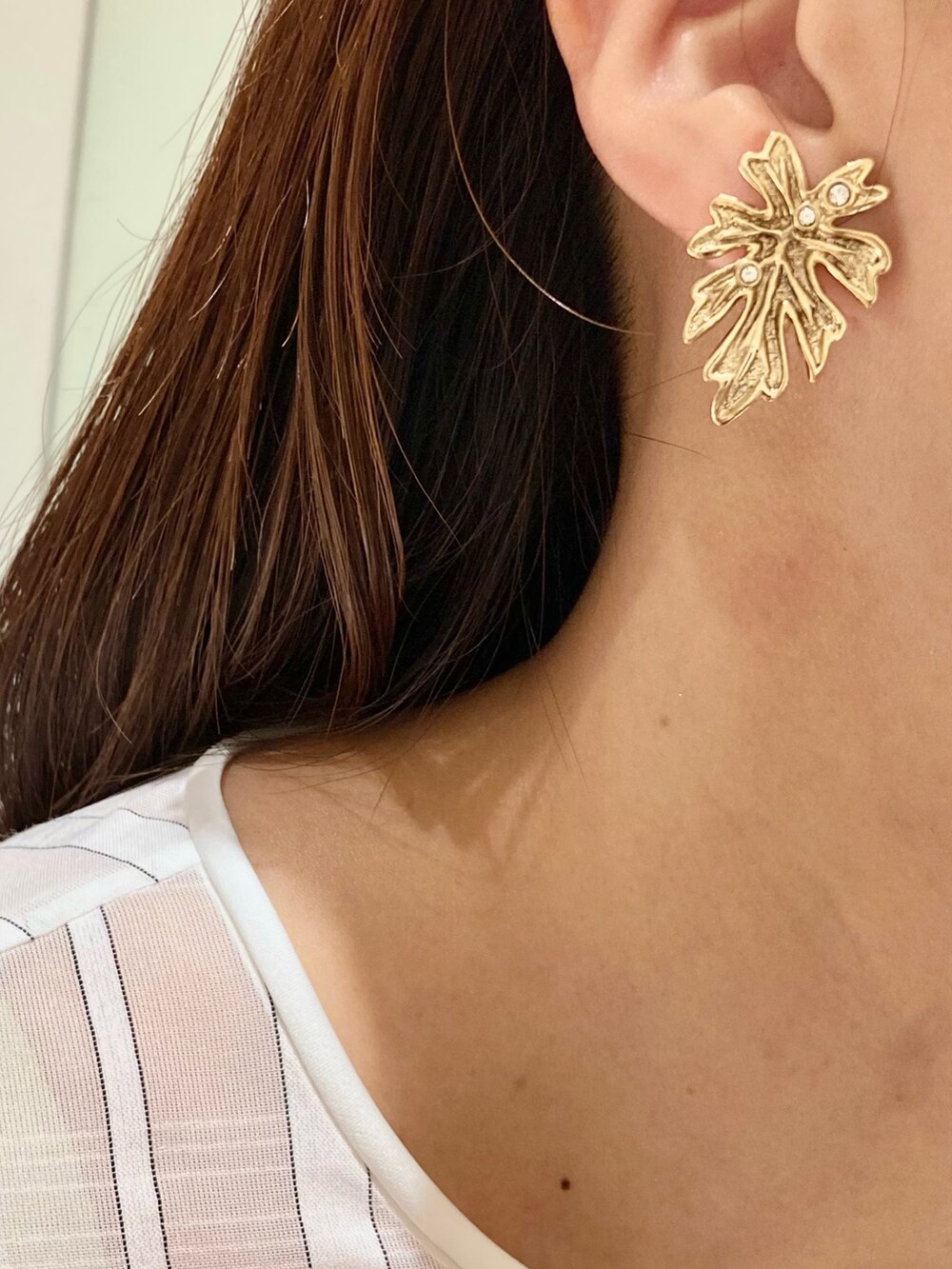 ホワイト系のシャツ/ブラウス、ブルー系のデニムパンツ、ゴールド系のイヤリングを着用したレディースの夏コーディネートの9枚目の写真