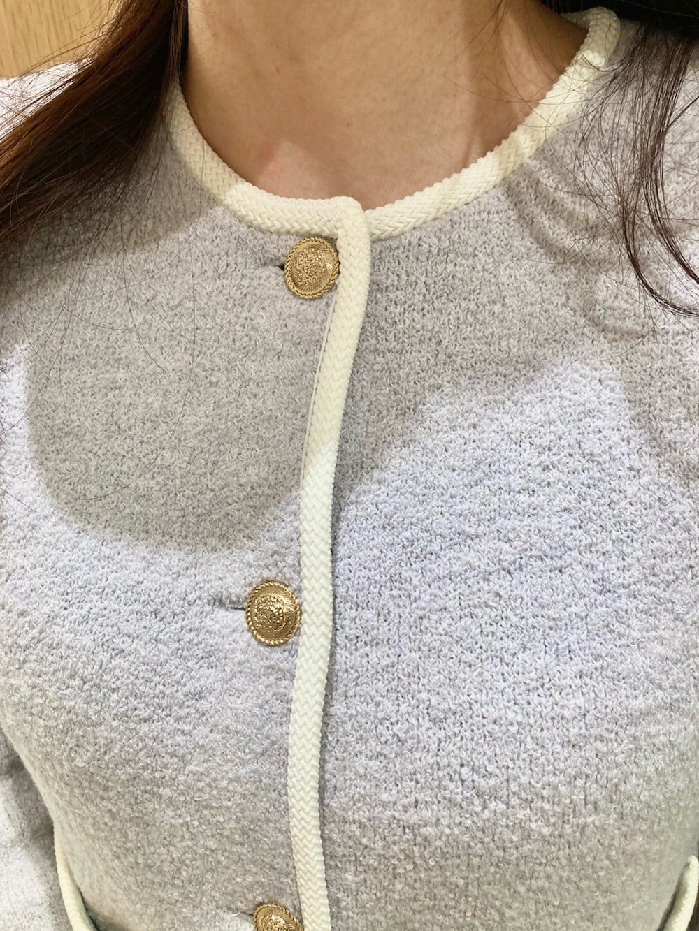 グレー系のカーディガン/ボレロ、ホワイト系のハンドバッグ、ホワイト系のスカートを着用したレディースの秋コーディネートの5枚目の写真