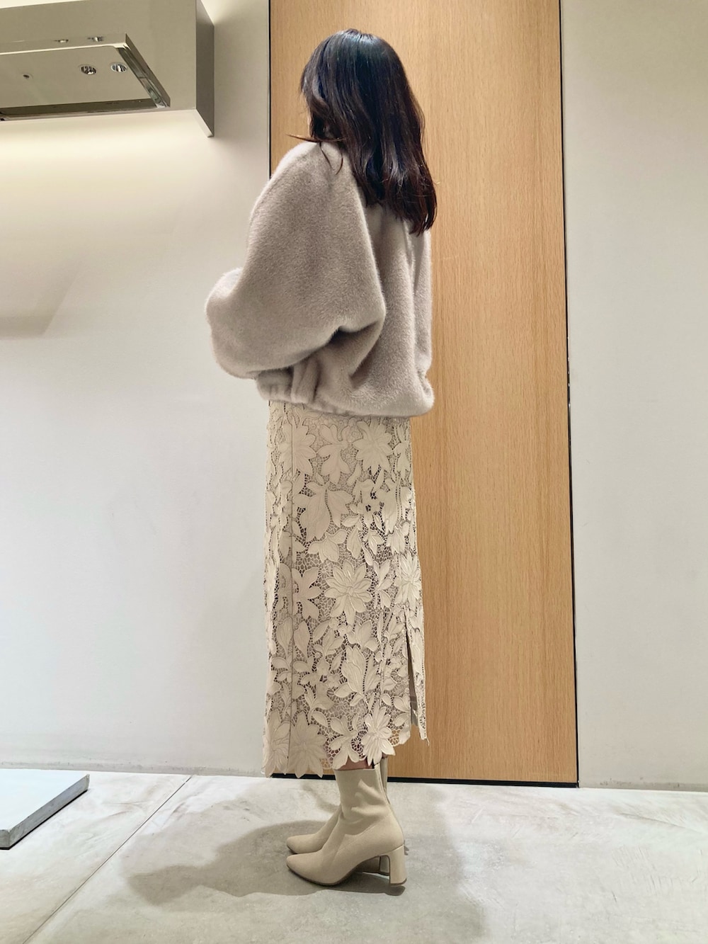 ベージュ系のブルゾン、ホワイト系のニット/セーター、ベージュ系のスカートを着用したレディースの秋コーディネートの3枚目の写真