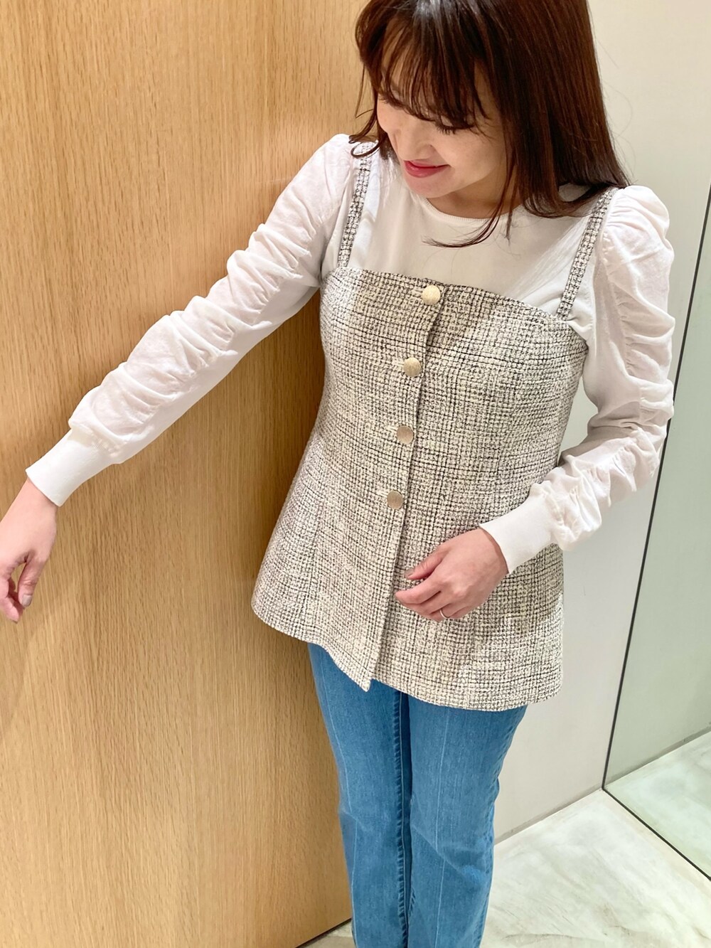 ホワイト系のニット/セーター、ホワイト系のベスト、ブルー系のデニムパンツを着用したレディースの春コーディネートの7枚目の写真