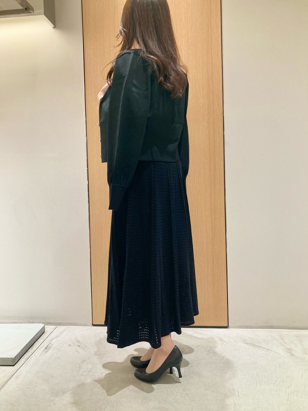 ブラック系のカーディガン/ボレロ、ブラック系のワンピース、レッド系のハンドバッグを着用したレディースの秋コーディネートの4枚目の写真