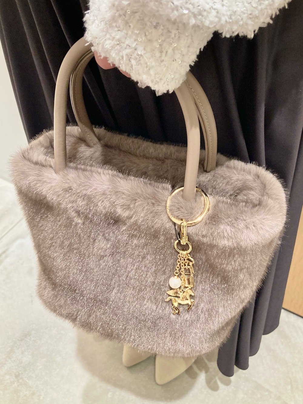 ホワイト系のカーディガン/ボレロ、ベージュ系のハンドバッグ、グレー系のスカートを着用したレディースの秋コーディネートの8枚目の写真