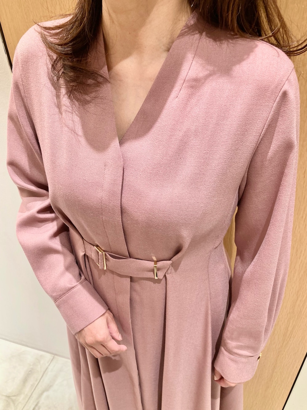 ピンク系のワンピース、ベージュ系のハンドバッグ、ゴールド系のリングを着用したレディースの秋コーディネートの4枚目の写真