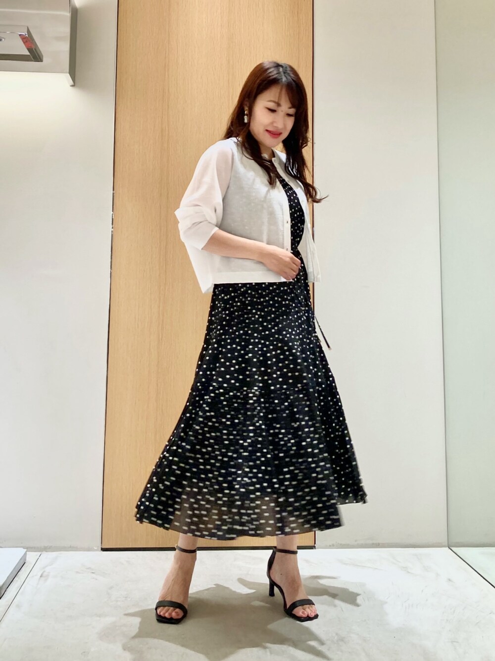 ホワイト系のカーディガン/ボレロ、ブラック系のワンピース、ホワイト系のイヤリングを着用したレディースの夏コーディネートの2枚目の写真
